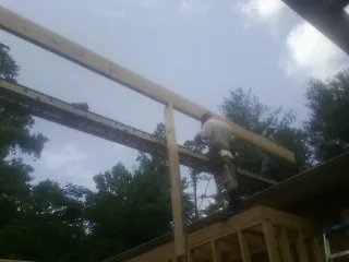 Carpenter setting a ridge beam over a new addition frame — Ice Dam Removal by Roofing Brothers in Millstone Township