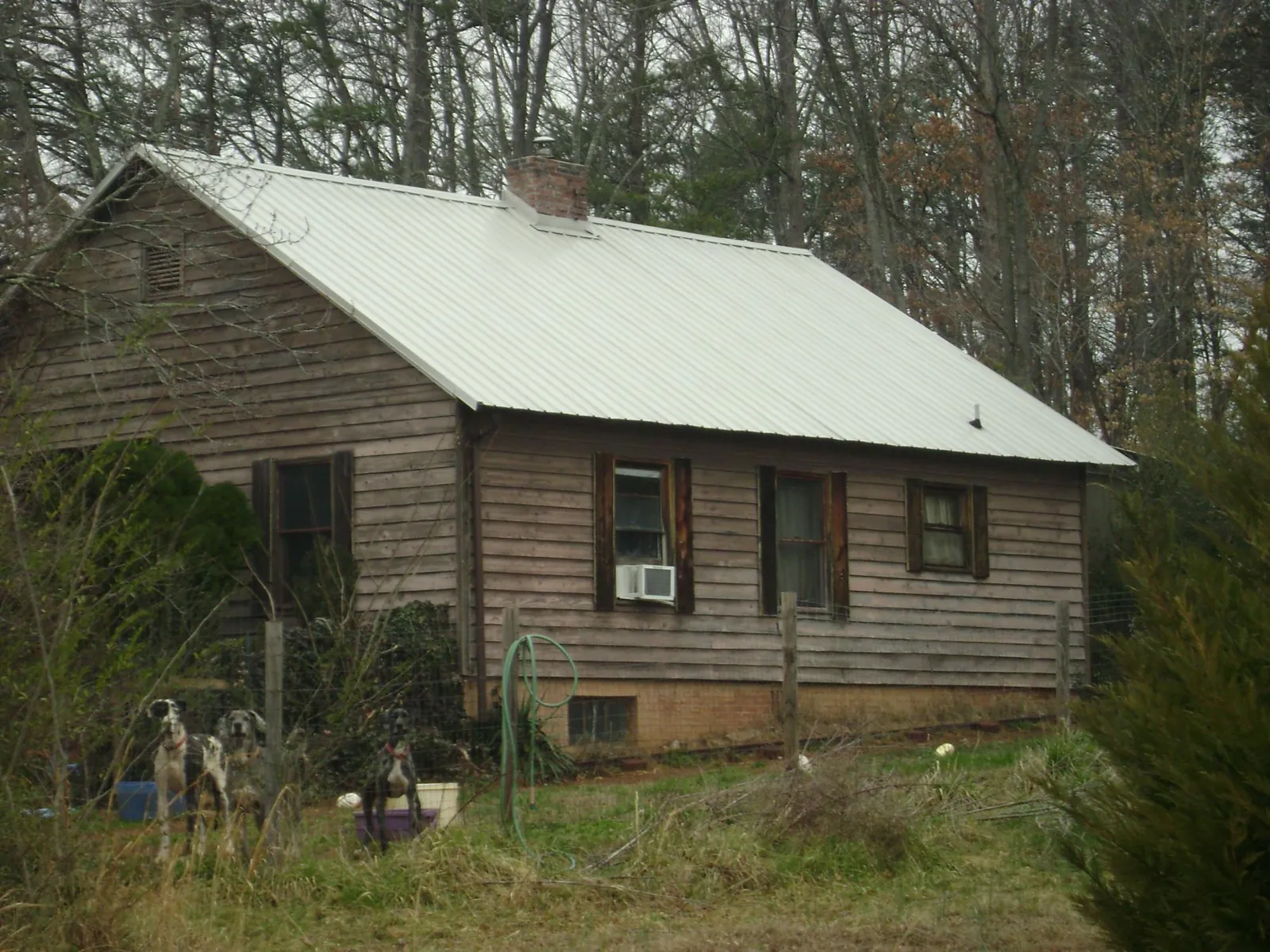 White metal roof on an old wood sided farmhouse, from a Metal Roof Installation job in Millstone Township